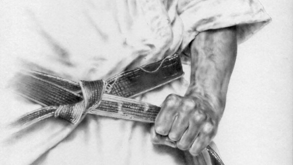Dettaglio del karate: pugno, cintura e gesto